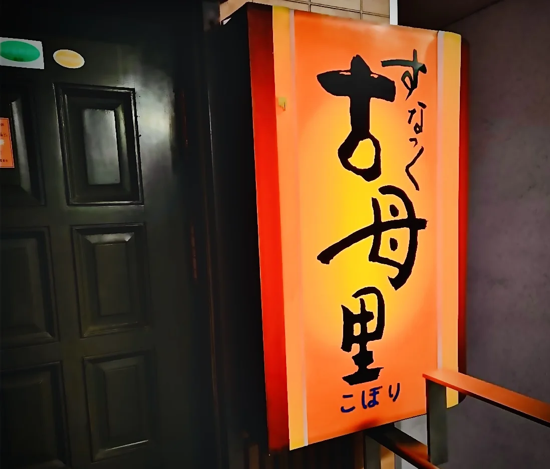 入口で灯りをともすスナック古母里の看板
